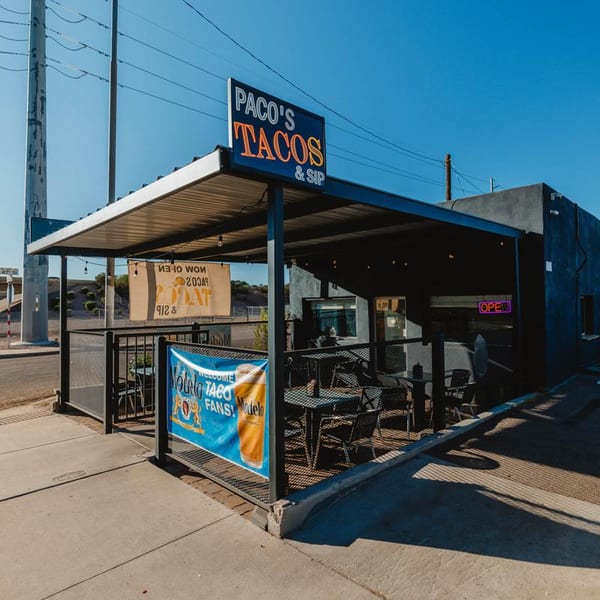 Paco's Tacos & Sip restaurant exterior with an outdoor patio under a shaded awning.